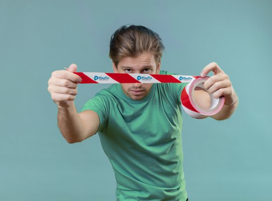 young handsome man wearing green t-shirt using adhesive tape in looking confident standing over green background 3